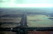 Aerial view of agricultural fields through the middle of which is a drainage canal