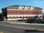 picture of a three story brick building across a street.