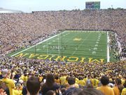 Crowded stadium with yellow-colored "Michigan" written on a green field