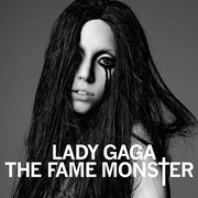 A brunette, whose black hair falls all around her face and covers her torso and right eye. Black eyeliner runs down her face in two streaks from her left eye. In front of her, the words "Lady Gaga" and "The Fame Monster" are written in white capital font, with the T of Monster being stylized as a cross (†).