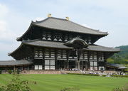 Huge  wooden building with white walls and dark  beams.