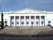 A white building with a triangular facade and wide stairs