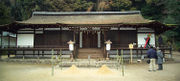 Frontal view of a rather low and  wide building with wooden beams and white painted walls.