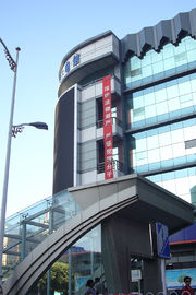 A vertical, red banner hanging high on a modern hotel with Chinese writing: "维护法律尊严，严惩犯罪分子"