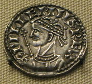 Coin image of a crowned male head with a sceptre in the background