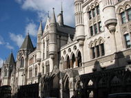 Ornate grey stone building with multiple turrets and arched windows.