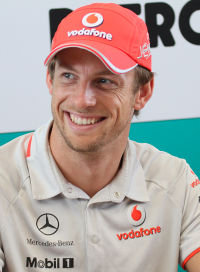 A man wearing a red cap and off-white top.