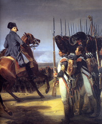 Napoleon, on a horse, looks across a line of bearskinned-hatted troops, one of the soldiers is breaking ranks and holding his hat up gesturing towards Napoleon