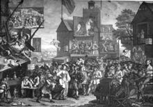 A complex, crowded street populated by spirited and laughable characters in 18th century dress. Two example scenes: A beautiful woman drummer and a dark boy trumpeter lead a procession past admirers and a man being arrested. A scaffold holding actors performing a play aloft falls and crashes into a china shop.