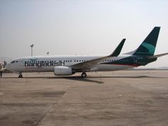 A white aircraft with Bangladesh written in green on the front half below the windows with a dark green colour on the tail facing left