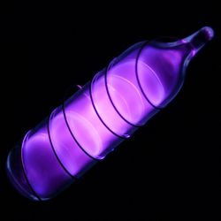 Glass tube shining violet-blue light with a wire wound over it