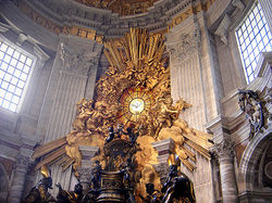 The chair-shaped bronze reliquary which holds the throne of St Peter is much larger than a normal chair, is ornate in shape and decorated with relief sculpture and gold leaf. The "Gloria" which surrounds a round window is a scuplture of clouds and sun-rays, surrounded by angels, the whole lot being covered in gleaming gold leaf.