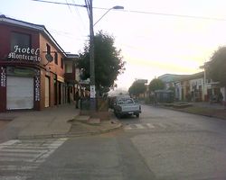 A street scene with low buildings and some vehicles