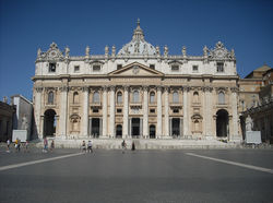 The façade, lit by floodlights, rises majestically against the night sky.