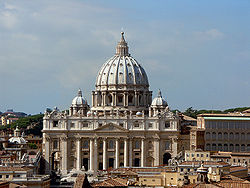 Photo. The facade is wide and has a row of huge columns rising from the basement to support the cornice. The ribbed, ovoid dome is surmounted by a lantern topped with ball and cross. Its drum is framed by two very much smaller domes.