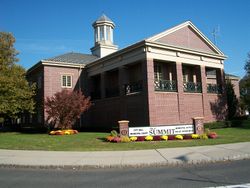 Picture of a modern brick two-story building with a steeple and a sign saying "Summit" City Hall