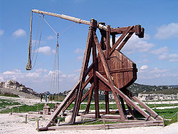 A tall wooden structure with a throwing arm counter balanced by a large weight