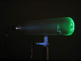 A glass tube containing a glowing green electron beam