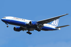 Aircraft landing approach. Front quarter view of twin-engine jet in flight with flaps and landing gear extended.