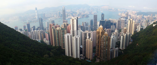 panorama: looking down on a city of skyscrapers, land mass in the distance separated by a body of water