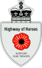 A Highway of Heroes reassurance marker. It is shaped and coloured like the 401 reassurance marker, except with a red poppy flower in place of the number 401. Above that is the text Highway of Heroes. In place of the word ONTARIO is SUPPORT OUR TROOPS.