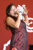 "Colour photograph of singer Tanya Tagaq singing into a microphone in a red dress at the Edmonton Folk Music Festival in August 2007"