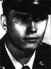 A black and white image of Michael wearing his military dress uniform with hat and necktie.