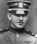 Head of a young man in military uniform with shoulder straps, a high, stiff, collar, and a cap.