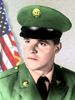 Head and shoulders of a young white man looking off to the side, wearing a peaked cap and a military jacket over a shirt and tie.