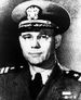 Head and shoulders of man in his forties, wearing glasses and a World War II style U.S. naval officer's uniform