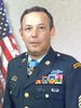 A colored photo of Littrell wearing his military dress uniform with ribbons and no hat. He looking at the camera and an American flag is visible in the background.