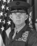 A black and white headshot of Livingston wearing his military dress uniform with a hat and ribbons. He is looking directly at the camera and there is an American flag in the background.