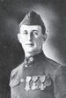 Head and shoulders of a man in a neatly pressed military uniform with three medals on his chest, a tight upright collar, and garrison cap.