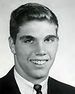 A black and white headshot image of Morgan in a suit and tie with no hat.