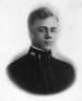 Head of a young man with carefully combed hair wearing a dark military tunic with an oak leaf emblem and bar on the upright collar.