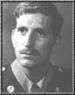 A black and white headshot of Miller wearing his military dress uniform with tie, mustache and no hat.