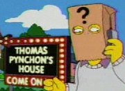 Cartoon frame showing a man with a paper bag over his head talking into a mobile phone. The bag has a large question mark printed on it and the man stands in front of a large illuminated sign in block letters which says 'THOMAS PYNCHON'S HOUSE - COME ON IN'