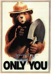 Drawing of a grizzly bear with human features. He is wearing blue jeans with a belt and a brimmed hat with the name "Smokey" on the cap, and has a shovel in his left hand. He is pointing to the viewer while the text "Only You" is seen below him.