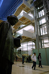 Patrons walking towards door in lobby with sculpture of possibly Athena on left