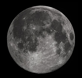 Full moon in the darkness of the night sky. It is patterned with a mix of light-tone regions and darker, irregular blotches, and scattered with varying sizes of impact craters, circles surrounded by out-thrown rays of bright ejecta.