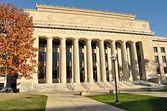 White-colored stone building with columns in the center of the facade