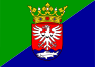 Flag diagonally split with green in the top left and blue on the bottom right with a centered coat of arms in the middle.