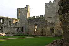 Ruined buildings inside the castle. There is a doorway leading to a ruined room, the kitchen range. In the background is the southeast tower.