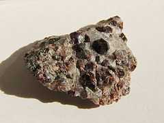 Dark red hexoctahedral crystals on light colored rock