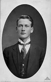 Black and white, head and shoulders portrait of a man in a suit.