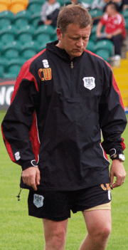 Photo of a man in a black coat and black shorts