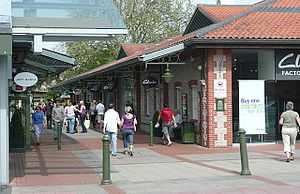 A busy pedestrian walkway through an open air shopping mall