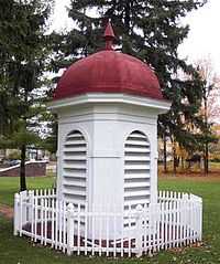 the red-roofed white cupola from the 1927 building, surrounded by a small white picket fence