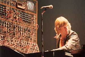 Keith Emerson performs with a complex synthesizer system that is barely visible through a mass of cables that connect its various modules