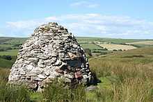 Mound of stones with fields in the background.